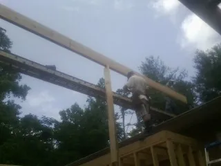 Carpenter setting a ridge beam over a new addition frame — Ice Dam Removal by Roofing Brothers in Hillsborough